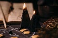 Open old book with magic spells, runes, black candles on witch table. Occult, esoteric, divination and wicca concept