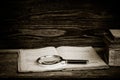 Open old book with a magnifying glass and a stack of books Royalty Free Stock Photo