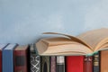 Open old book on others near blue wall Royalty Free Stock Photo