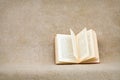 Open old book on a rough brown sacking Royalty Free Stock Photo