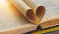 An open old book with sheets in the shape of a heart Royalty Free Stock Photo