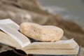 Open old book with stone bookmark on the rocks Royalty Free Stock Photo