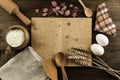 Open old vintage book on the aged wooden background. Kitchen utensils, ears of wheat, flour in a pot. Royalty Free Stock Photo