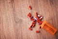 An open orange bottle of brightly coloured pills spilled onto a wooden table. Vitamin supplements are a great way to Royalty Free Stock Photo