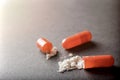 Open orange capsule pill with white powder drug