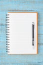Open orange Notebook and pen on blue wood table for work Royalty Free Stock Photo