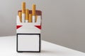 Open pack of cigarettes and a cigarette on a white background. Royalty Free Stock Photo
