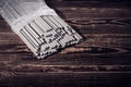 Open pack of welding electrodes on a wooden background. Studio photo in hard light