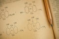 Open page of old chemistry book with chemical formulas and pencil