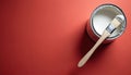 Open paint can with white liquid and brush on red surface. Ready for wall renovation or home decor project. Copy space for text Royalty Free Stock Photo