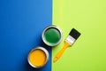 Open paint cans and brush on color background