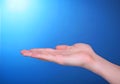 Open palm empty hand on blue background showing ho