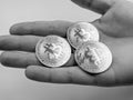 Open palm full of bitcoins in black and white offering to pay with collected cryptocurrency invested in through mining Royalty Free Stock Photo