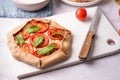 Open pie, vegetarian pizza galette with feta cheese, spinach and tomato