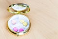 Open pillbox with pink and yellow pills Royalty Free Stock Photo