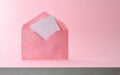 Open pink envelope with hearts coming out on pink background