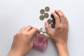 open pink wallet with scattered coins and hands on a white background Royalty Free Stock Photo