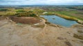 Open pit gravel mining site with lake or pond of unusual shape and beautiful autumn nature, gravel piles photographed with drone Royalty Free Stock Photo