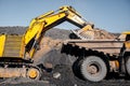 Open pit mine industry, excavator loading coal on big yellow mining truck for anthracite Royalty Free Stock Photo