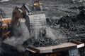 Open pit mine industry. Excavator work loading of coal into Yellow mining truck Royalty Free Stock Photo