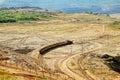 Open-pit mine, mining train carrying excavated materials. Mining machines in the background. Royalty Free Stock Photo