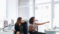 Open plan makes for open dialogue. two young businesswomen using a computer together in a modern office. Royalty Free Stock Photo