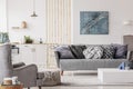 Open studio apartment with small white kitchen and living room with grey couch and wooden coffee table Royalty Free Stock Photo