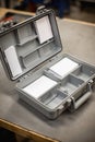 Open plastic first aid kit on a workshop table with organized empty compartments Royalty Free Stock Photo