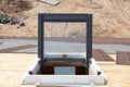 Open plastic mansard or skylight window on a asphalt shingle roof.