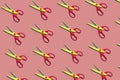 Open plastic yellow and red scissors on pastel pink color background. Seamless colorful pattern Royalty Free Stock Photo