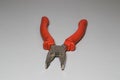 Open pliers with red handles on the table