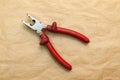 Open pliers with red rubber handles used during work to clamp parts for craftsmanship in the tool workshop. Items for production