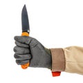 Open pocket folding knife with bright orange handle clenched in a worker fist in black protective glove isolated on white Royalty Free Stock Photo