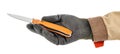 Open pocket folding knife with bright orange handle lies in palm of worker hand in black protective glove and brown uniform Royalty Free Stock Photo