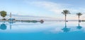 Open pool on the shores of the exotic ocean and the reflection of palm trees in the water. summer landscape. panoramic picture Royalty Free Stock Photo