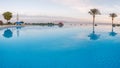 Open pool on the shores of the exotic ocean and the reflection of palm trees in the water. summer landscape. panoramic picture Royalty Free Stock Photo