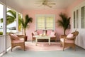 an open porch of a soft pink beachside cottage with wooden furniture
