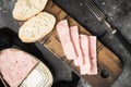 Open pork luncheon meat can with baguette, on black dark stone table background, top view flat lay Royalty Free Stock Photo