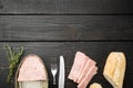 Open pork luncheon meat can with baguette, on black wooden table background, top view flat lay, with copy space for text Royalty Free Stock Photo