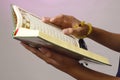 The open Qur& x27;an is held by the hand holding the prayer beads & x28;tasbih& x29;. The Qur& x27;an is the holy book of Islam Royalty Free Stock Photo