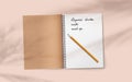 Open realistic notebook with pencil on abstract soft delicate beige background falling shadow overlay from plant. Royalty Free Stock Photo