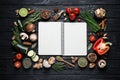 Open recipe book and different ingredients on black table, flat lay. Space for text Royalty Free Stock Photo