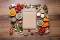 Open recipe book and different ingredients on wooden table, flat lay. Space for text Royalty Free Stock Photo