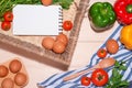 Open recipe book with fresh vegetables on wooden table. Royalty Free Stock Photo