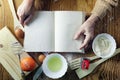 Open recipe book in the hands of an elderly woman