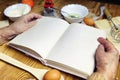 Open recipe book in the hands of an elderly woman