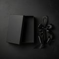 An open rectangular black gift box rests on a textured black surface. The box is empty, with its Royalty Free Stock Photo