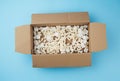 Open rectangular brown cardboard box with white foam filling