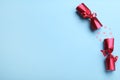 Open red Christmas cracker with shiny confetti on light blue background, top view. Space for text Royalty Free Stock Photo