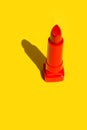 Open red crimson lipstick on solid yellow background. Bright sunlight strong shadows. Creative minimalist funky style pop art Royalty Free Stock Photo